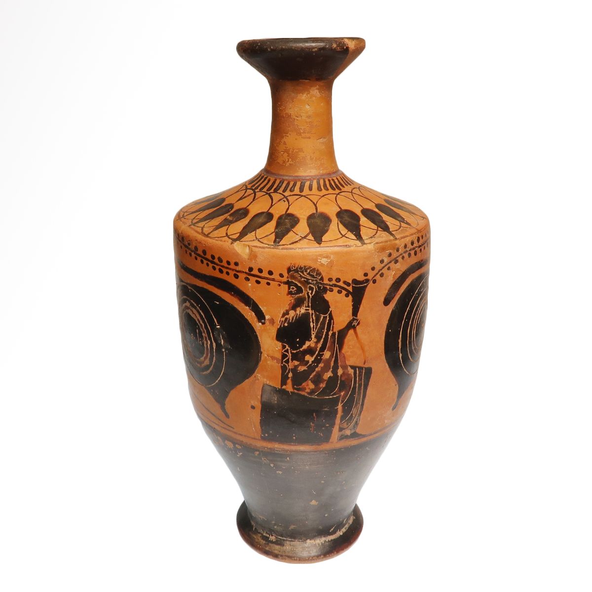 Attic black-figure eye-lekythos: a seated figure holding a drinking horn between two large apotropaic eyes, with a band of lotus buds on the shoulder and black gloss over the lower body.